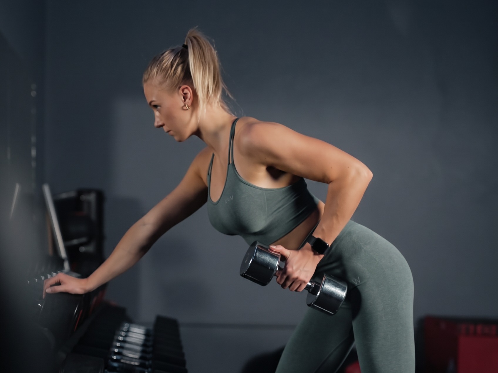 Kvinna tränar med hantel i gymmet på Hitness